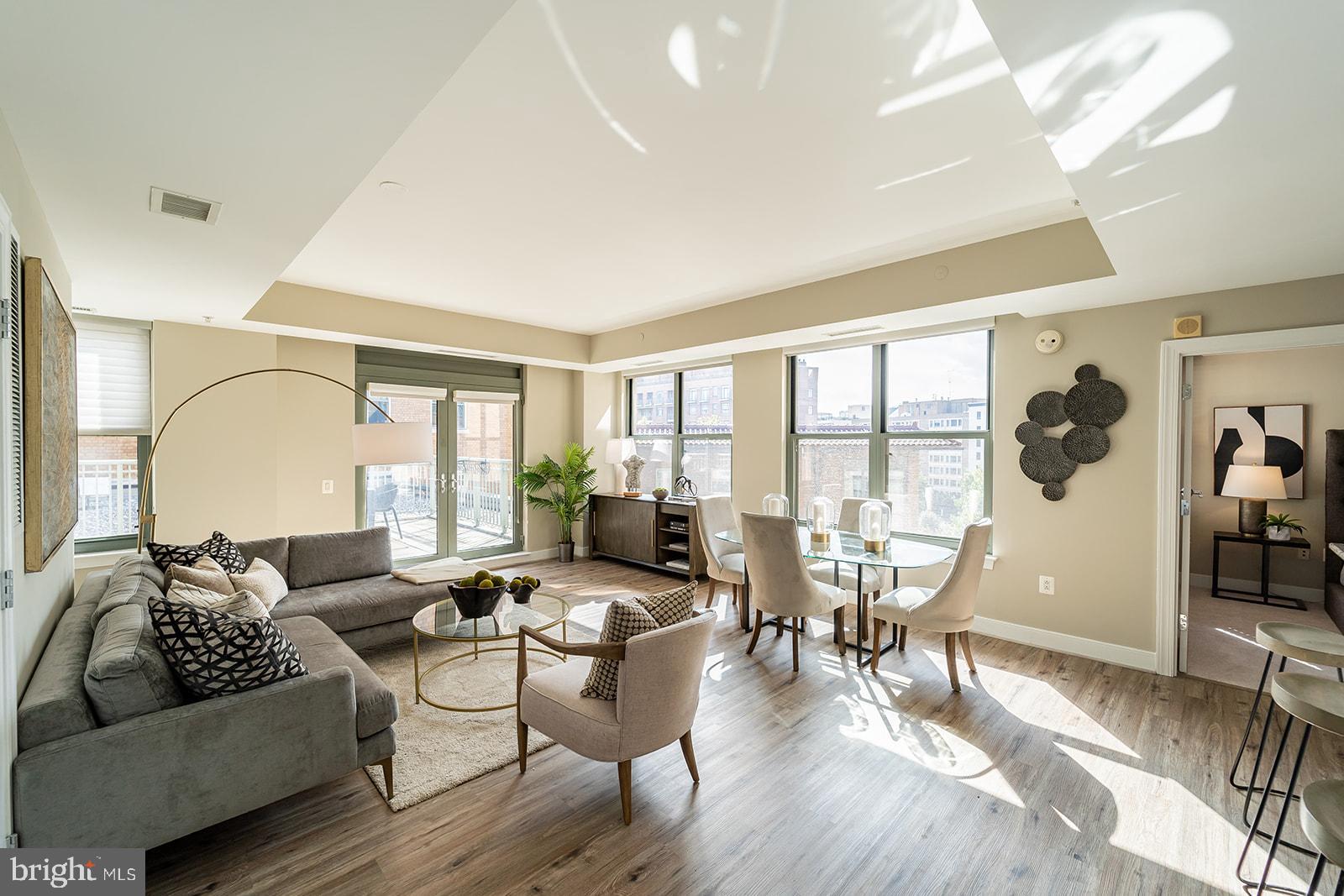 a living room with furniture and a large window with wooden floor