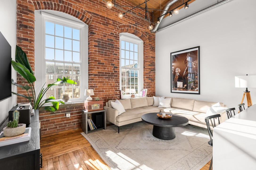 a living room with fireplace furniture and a potted plant