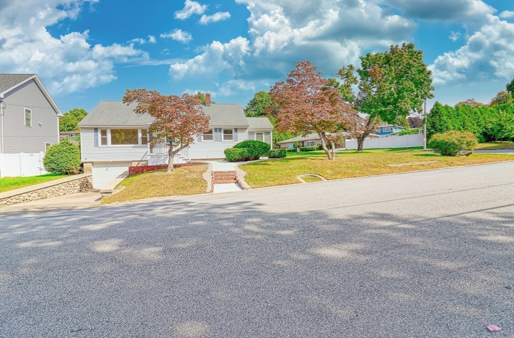 a view of a house with a big yard and large trees