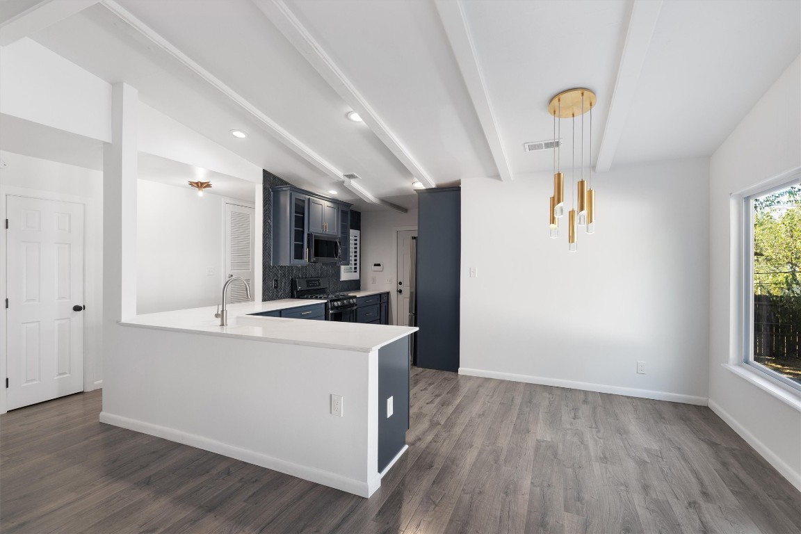 a view of a kitchen with wooden floor and electronic appliances