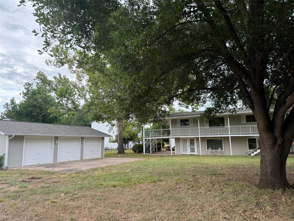 a view of a house with a yard and large tree