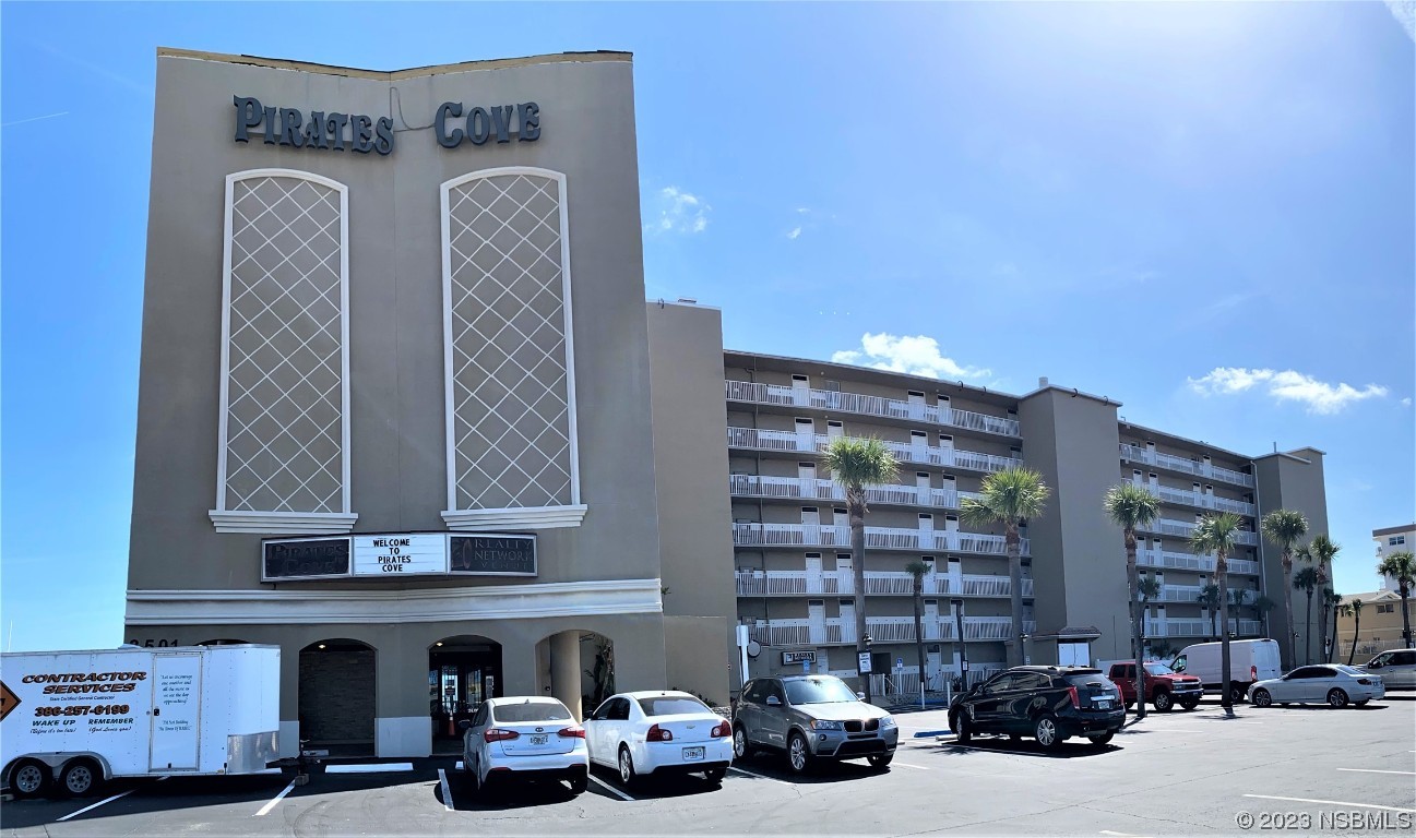 a view of a building with cars parked