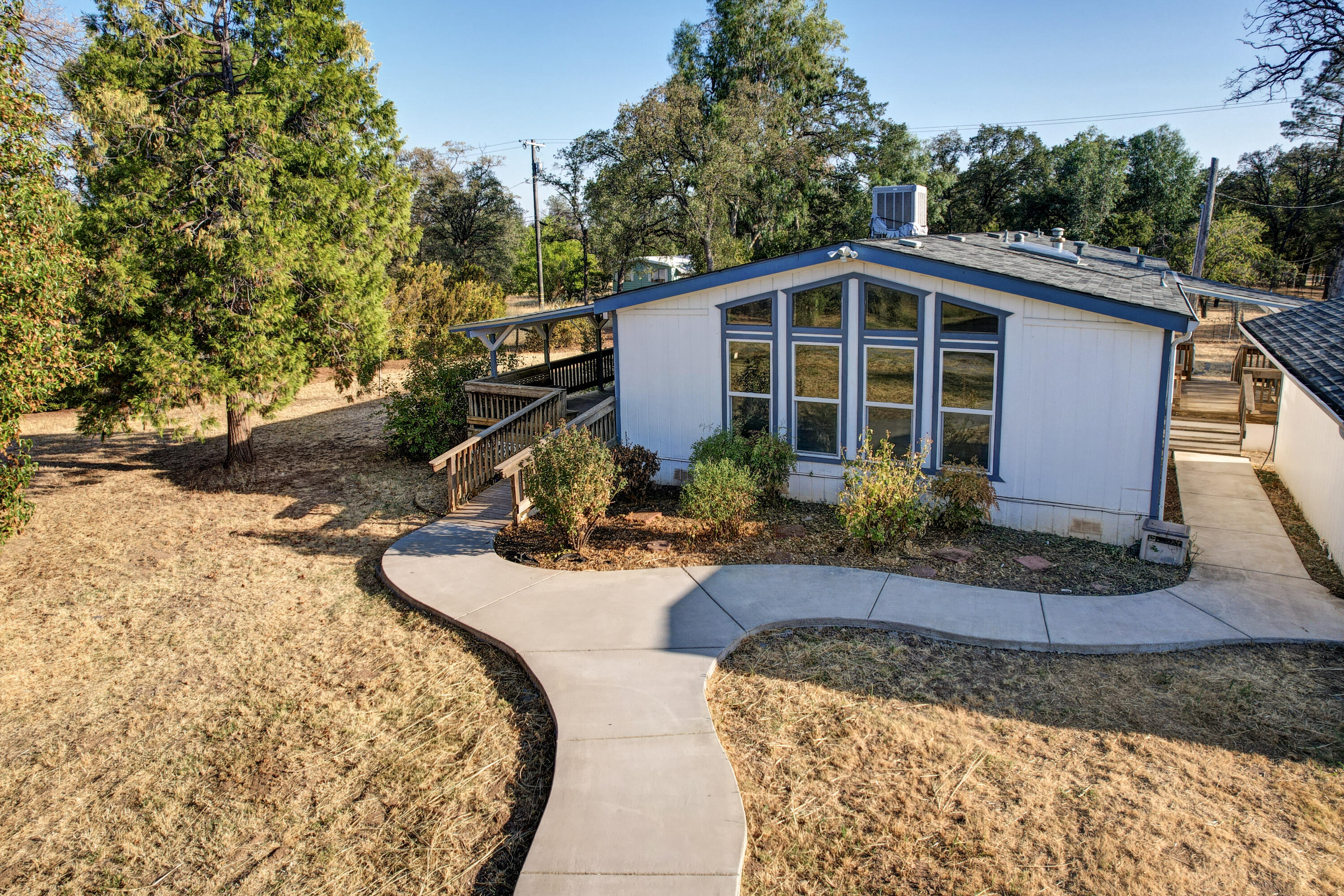 a view of a house with backyard fire pit and a tree