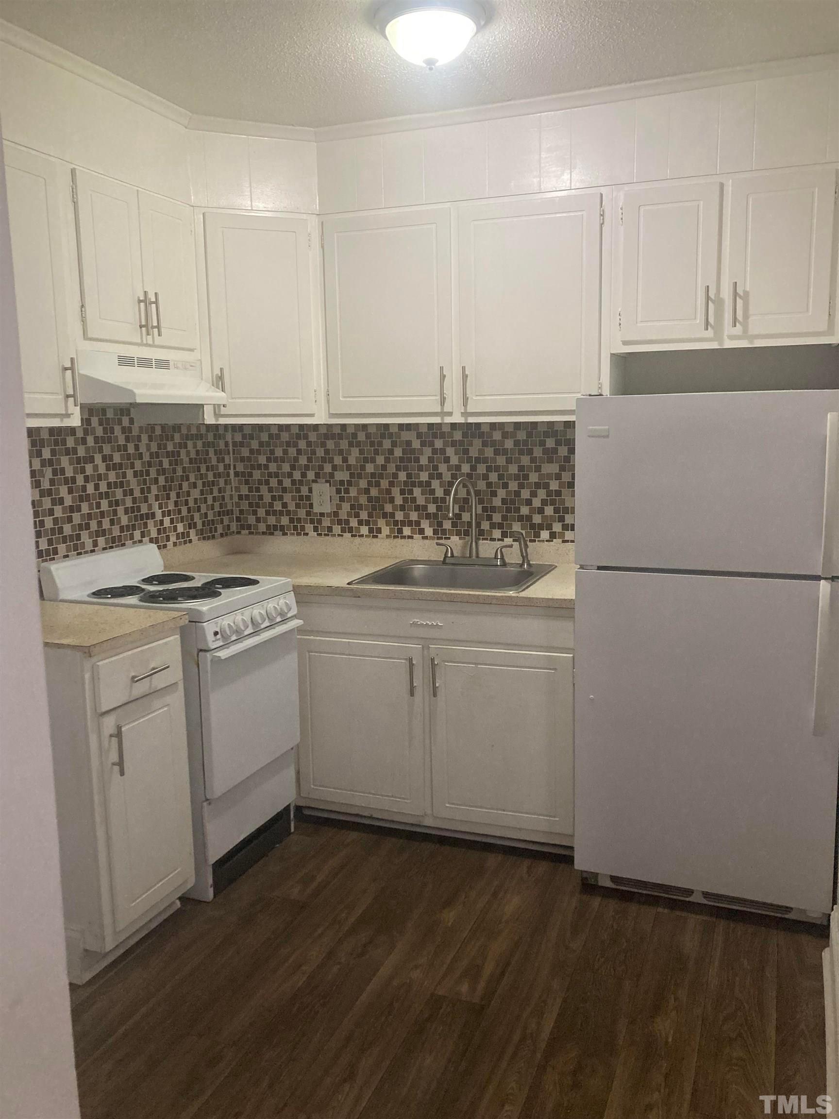 a kitchen with white cabinets and white appliances