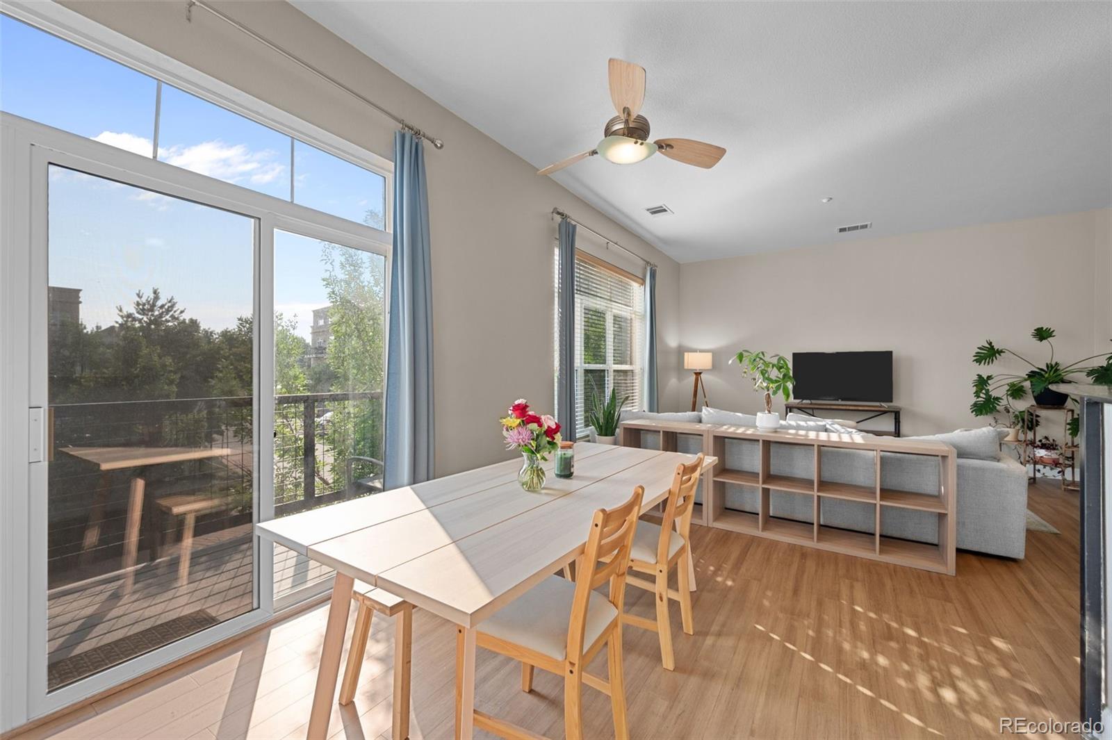 a living room with furniture a flat screen tv and a large window