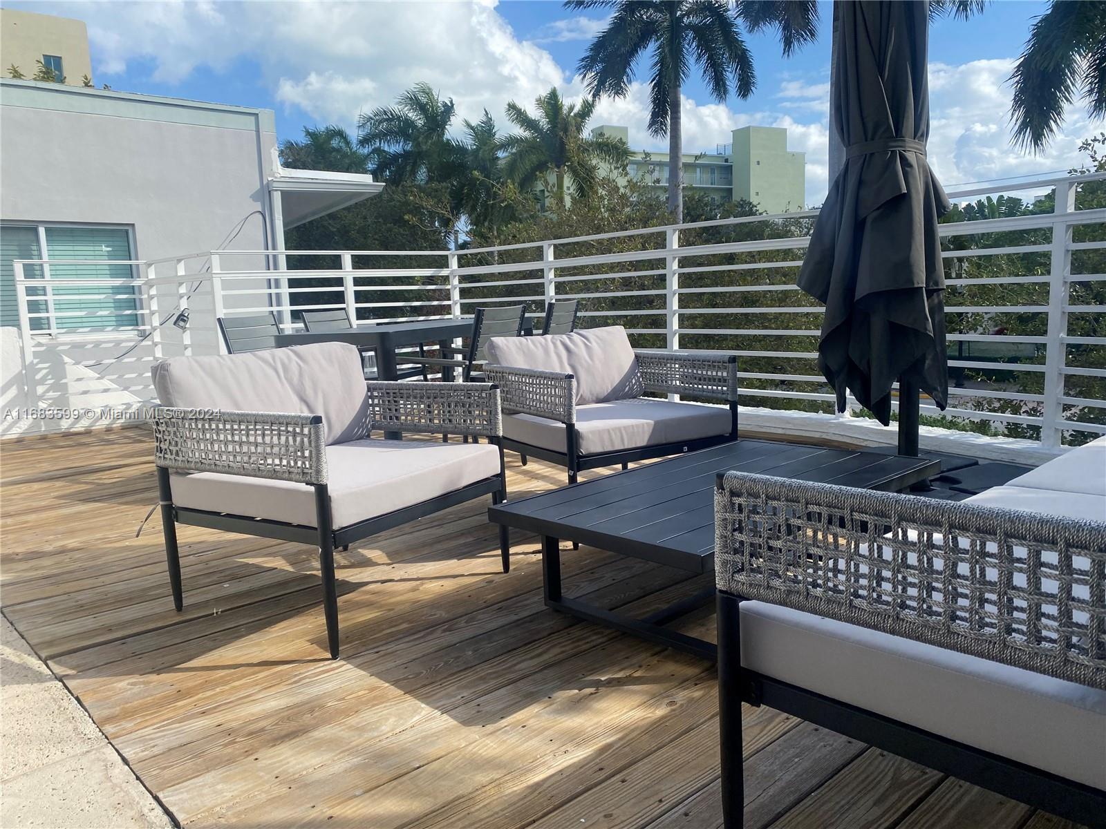 a roof deck with couches and wooden floor