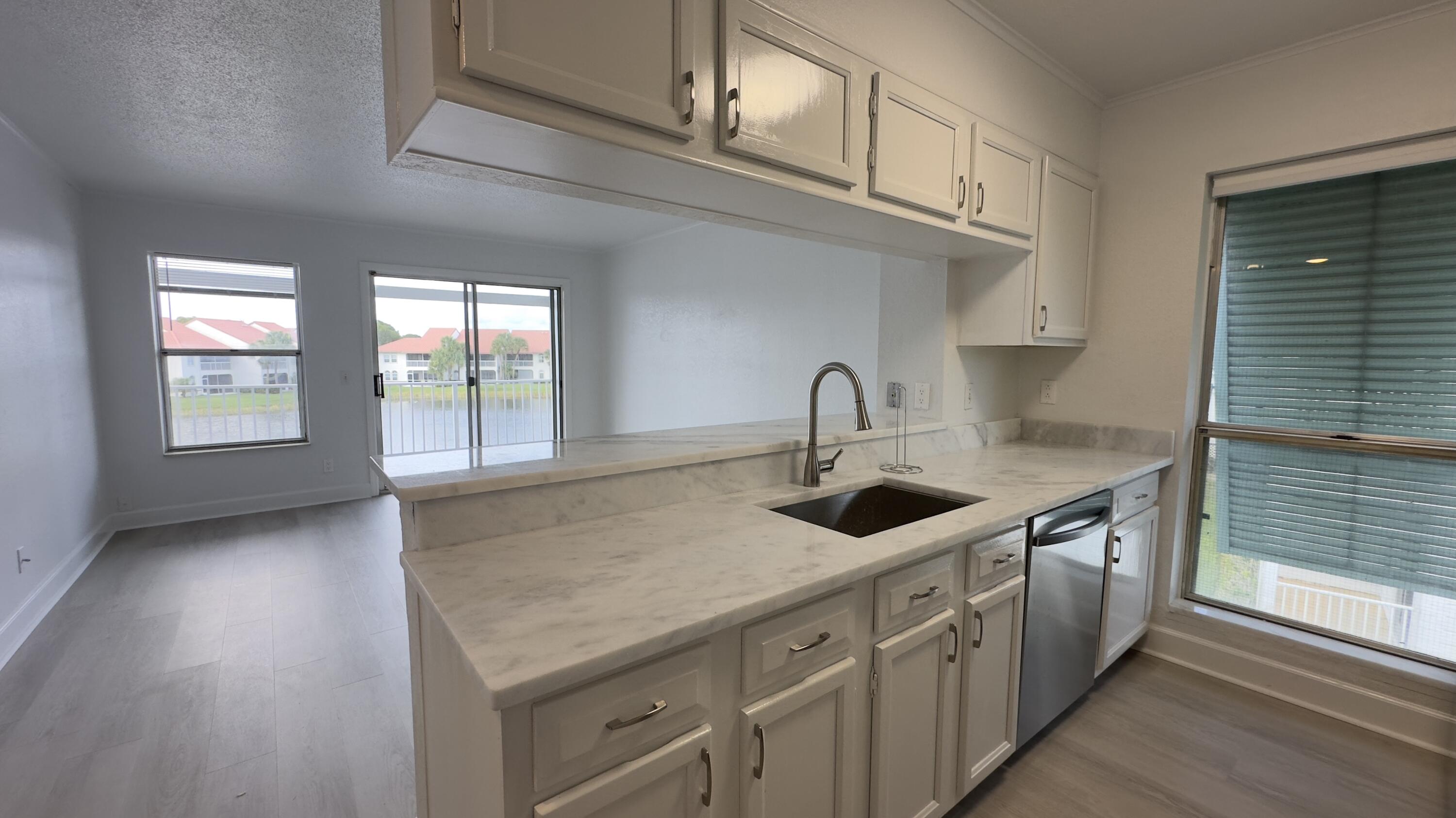 a kitchen with stainless steel appliances granite countertop a sink a stove and a wooden floors