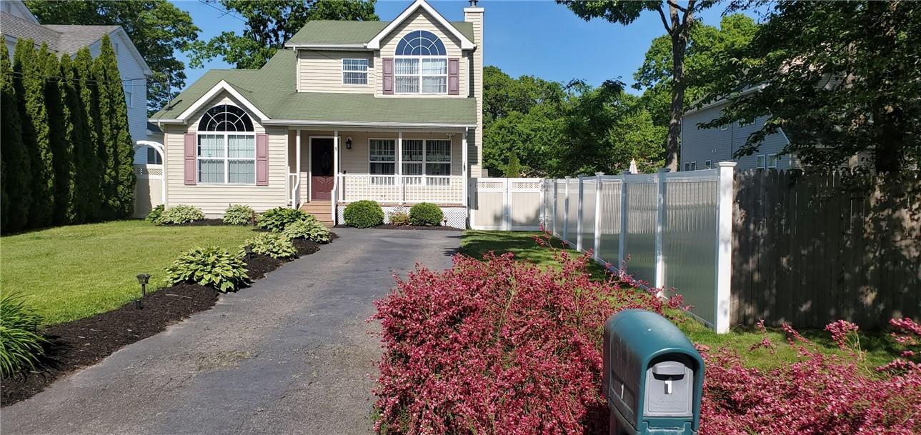 a front view of a house with a yard and potted plants