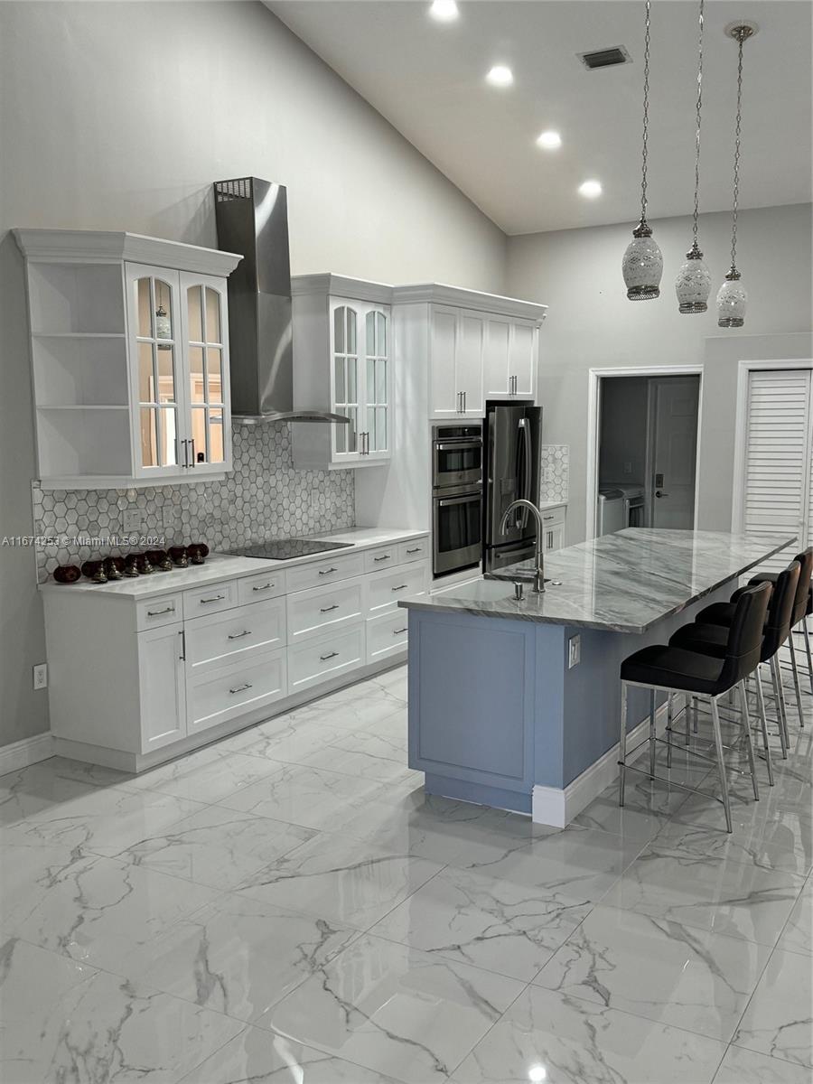 a large kitchen with granite countertop a stove and cabinets