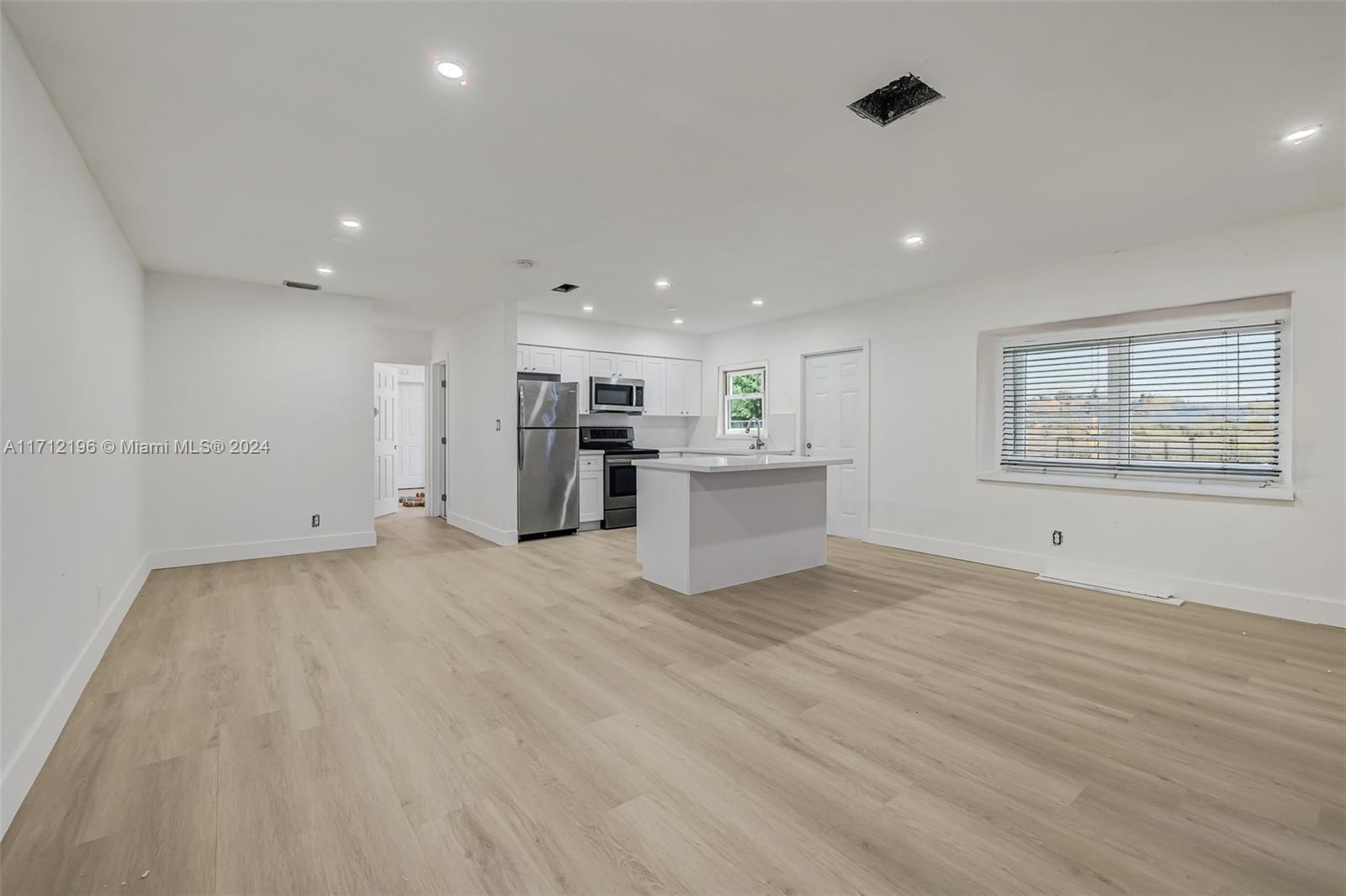 a view of a kitchen with furniture and refrigerator