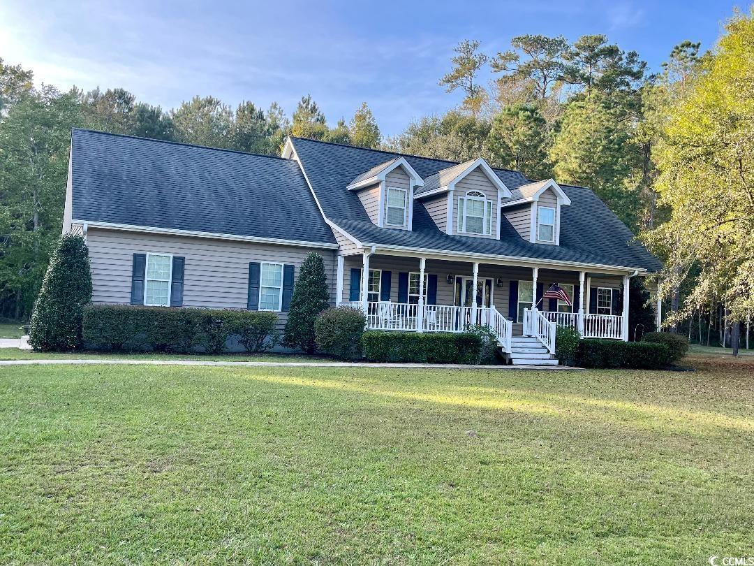 Cape cod home with a front yard and a porch