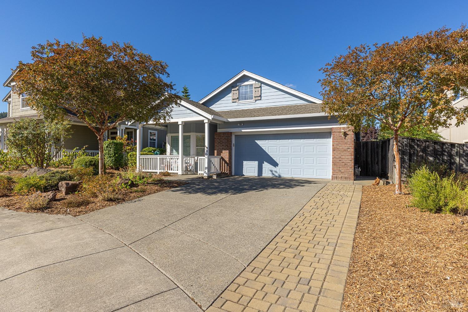 a front view of a house with a yard and potted plants