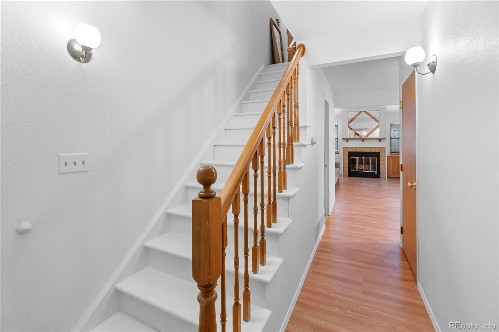 a view of a hallway with wooden floor and staircase