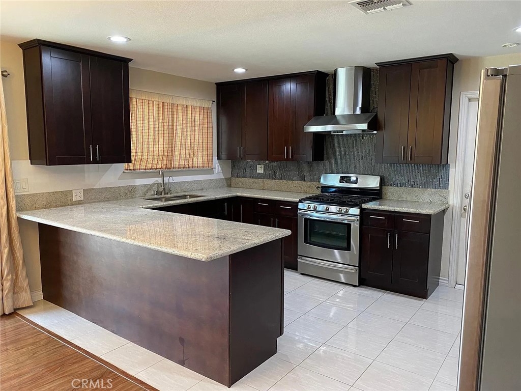 a kitchen with stainless steel appliances a sink stove and refrigerator