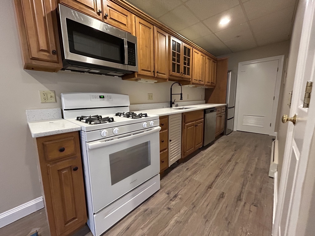 a kitchen with stainless steel appliances a stove a microwave a sink and cabinets