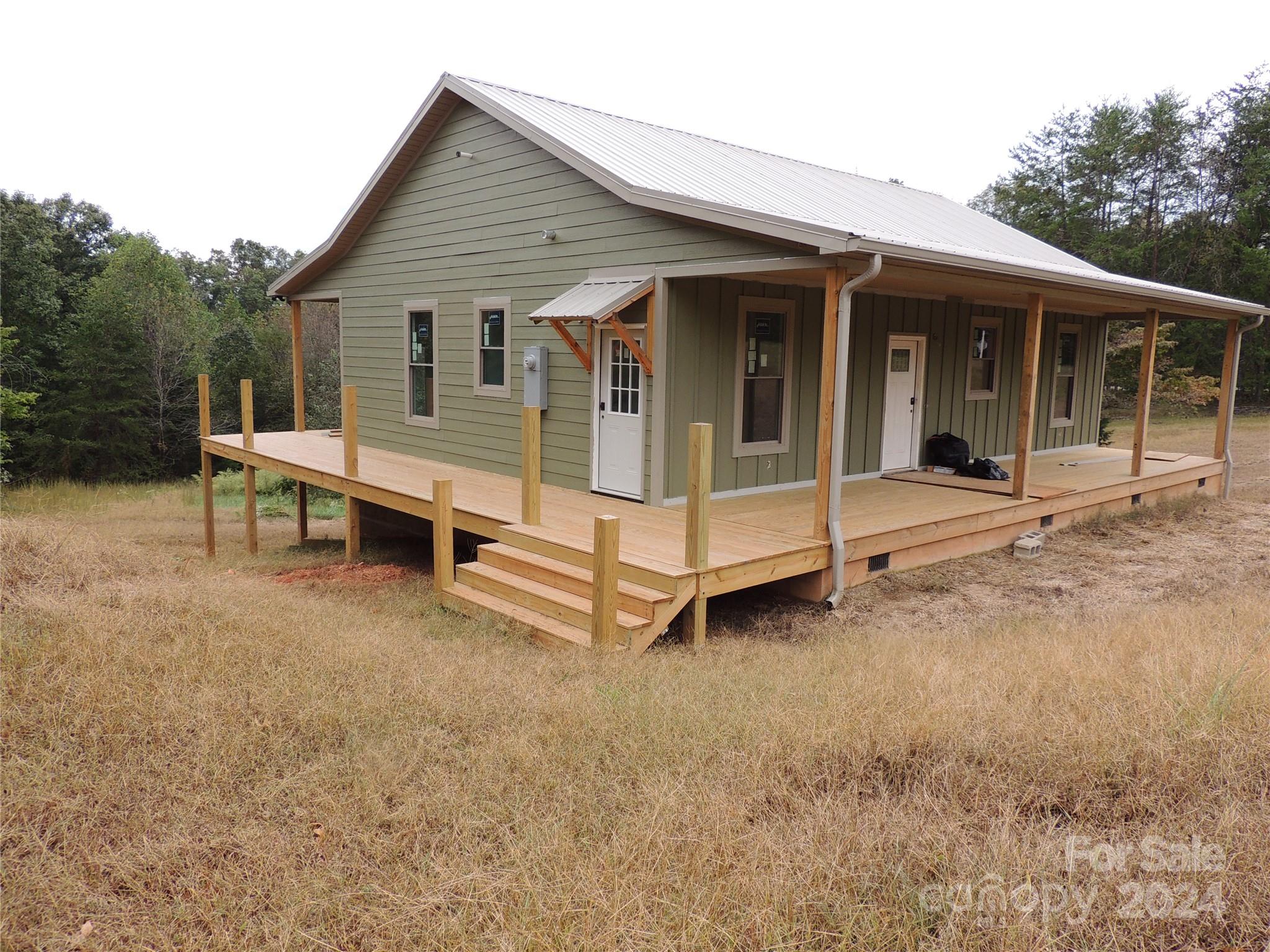 a view of a house with a yard and sitting area