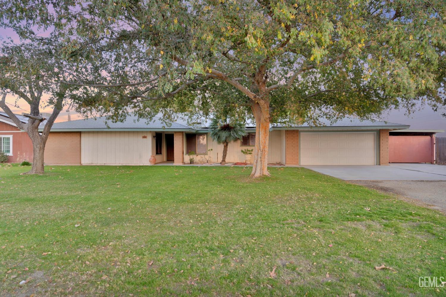 a front view of house with yard and trees