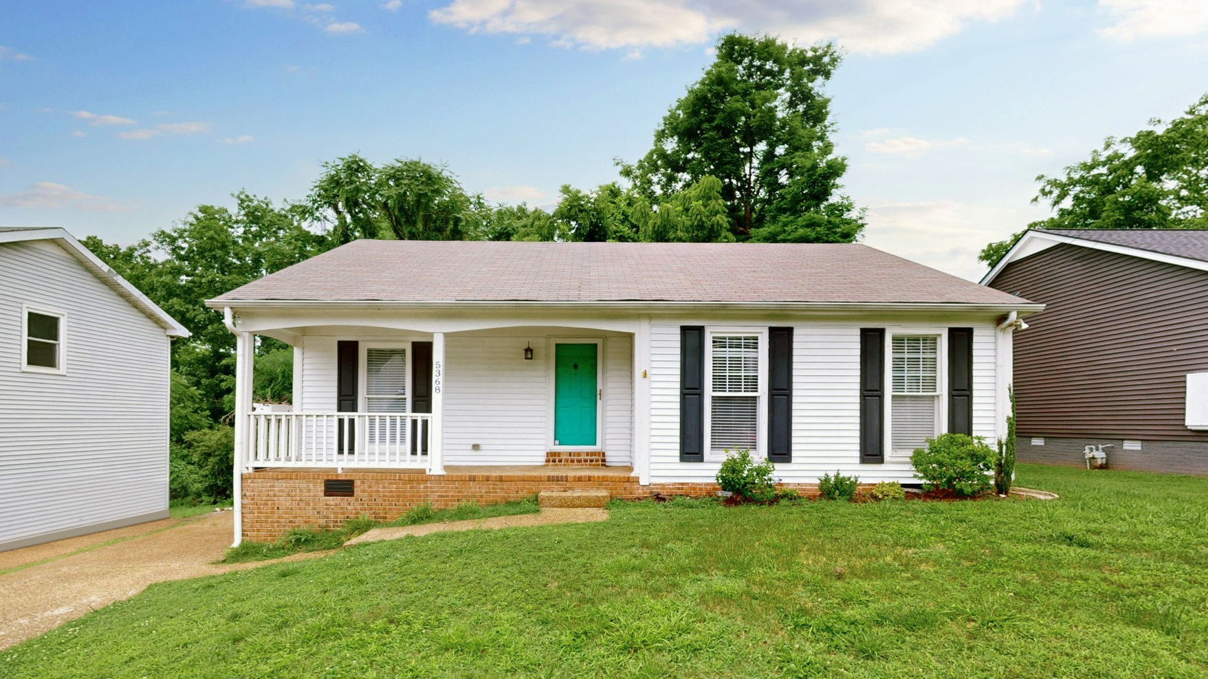 a view of a house with a yard and potted plants