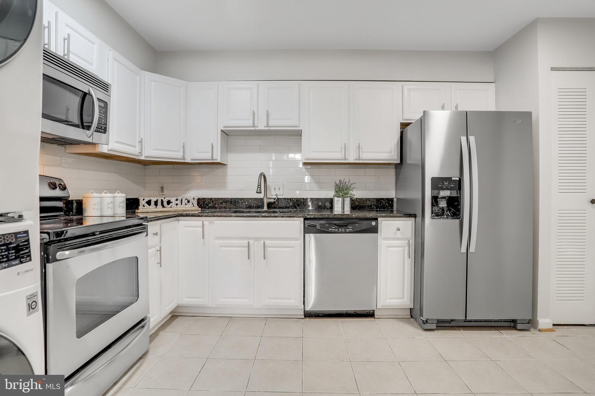 a kitchen with stainless steel appliances granite countertop a refrigerator sink and stove