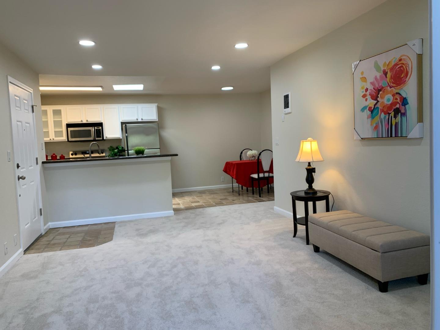 a living room with furniture and kitchen view