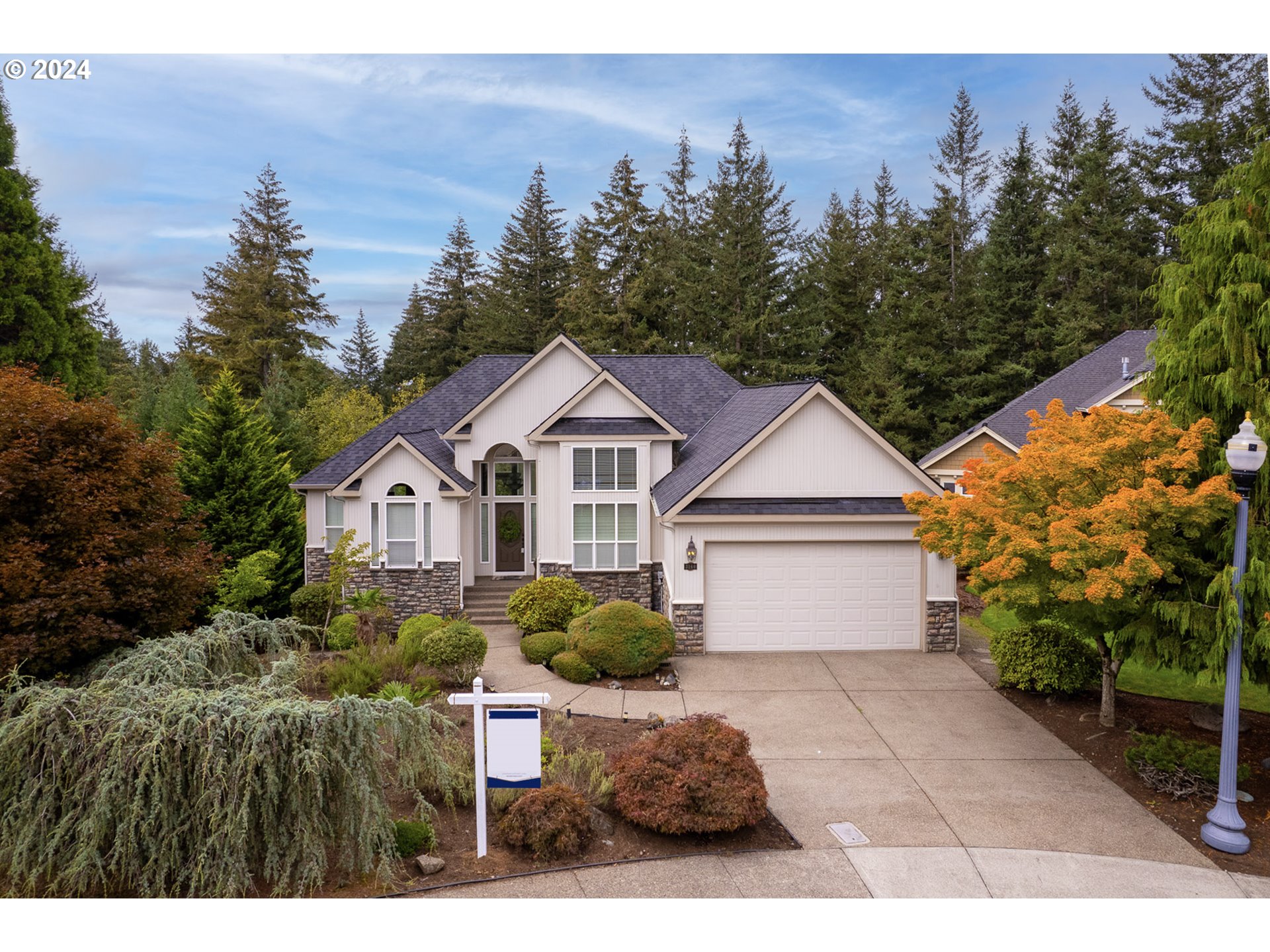 a front view of a house with a yard and trees