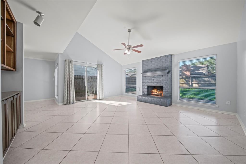 a view of an empty room with a fireplace and a window