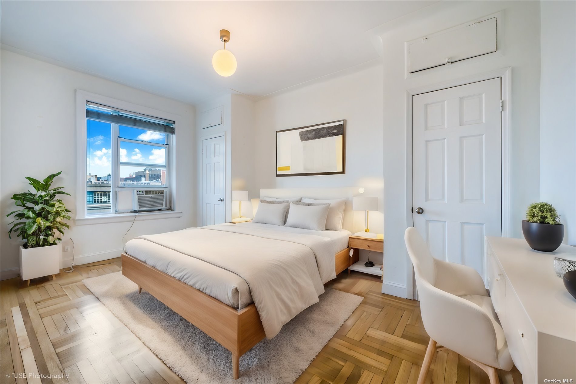 a spacious bedroom with a bed and potted plant