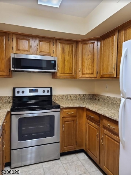 a kitchen with granite countertop a stove microwave and cabinets