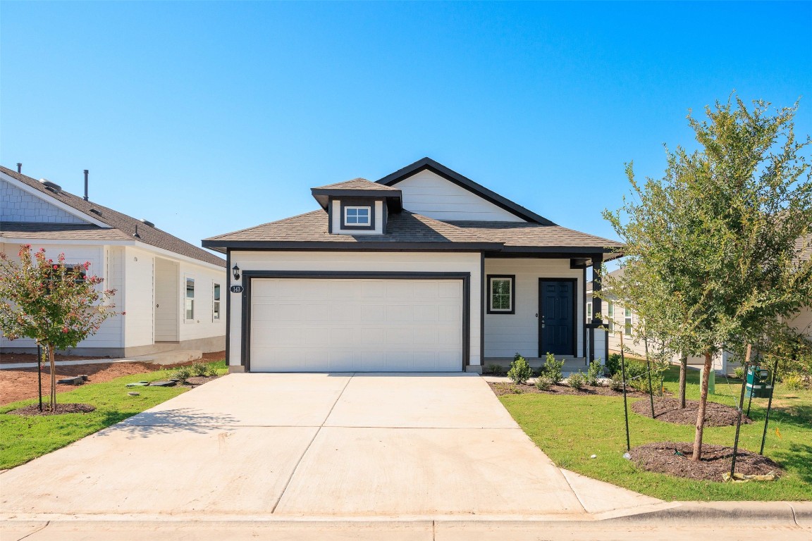 a front view of a house with a yard and garage