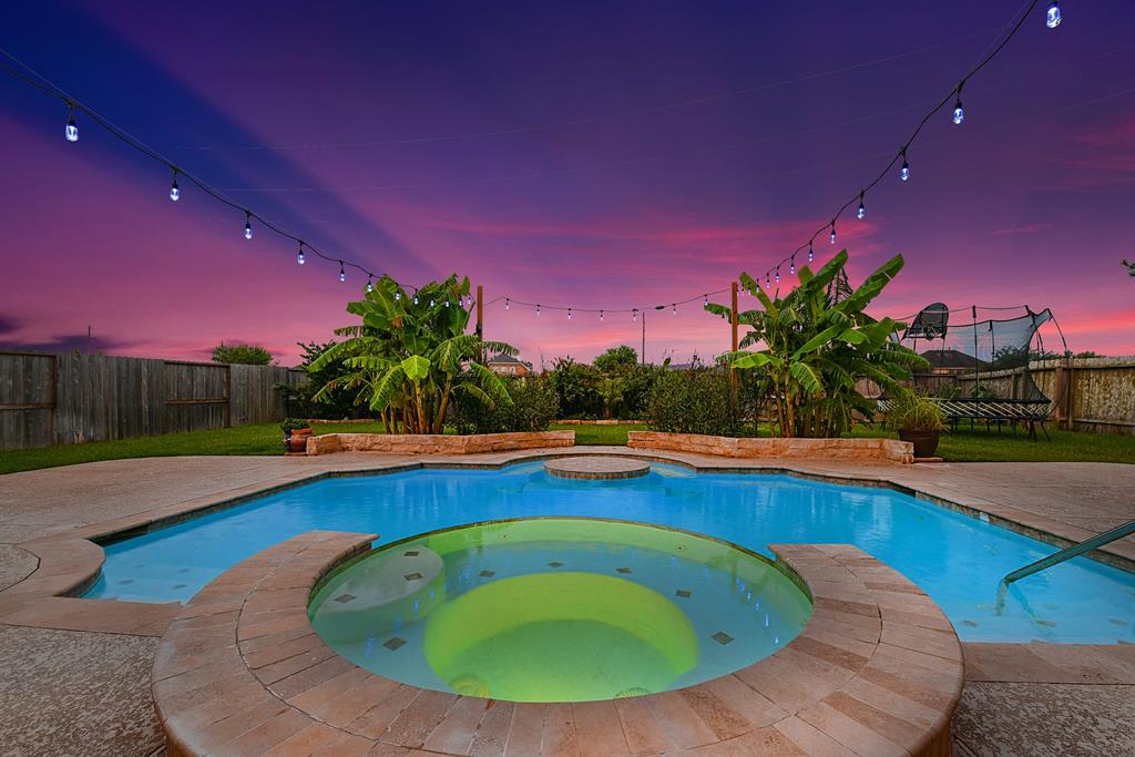 a view of a swimming pool with a yard and a fire pit