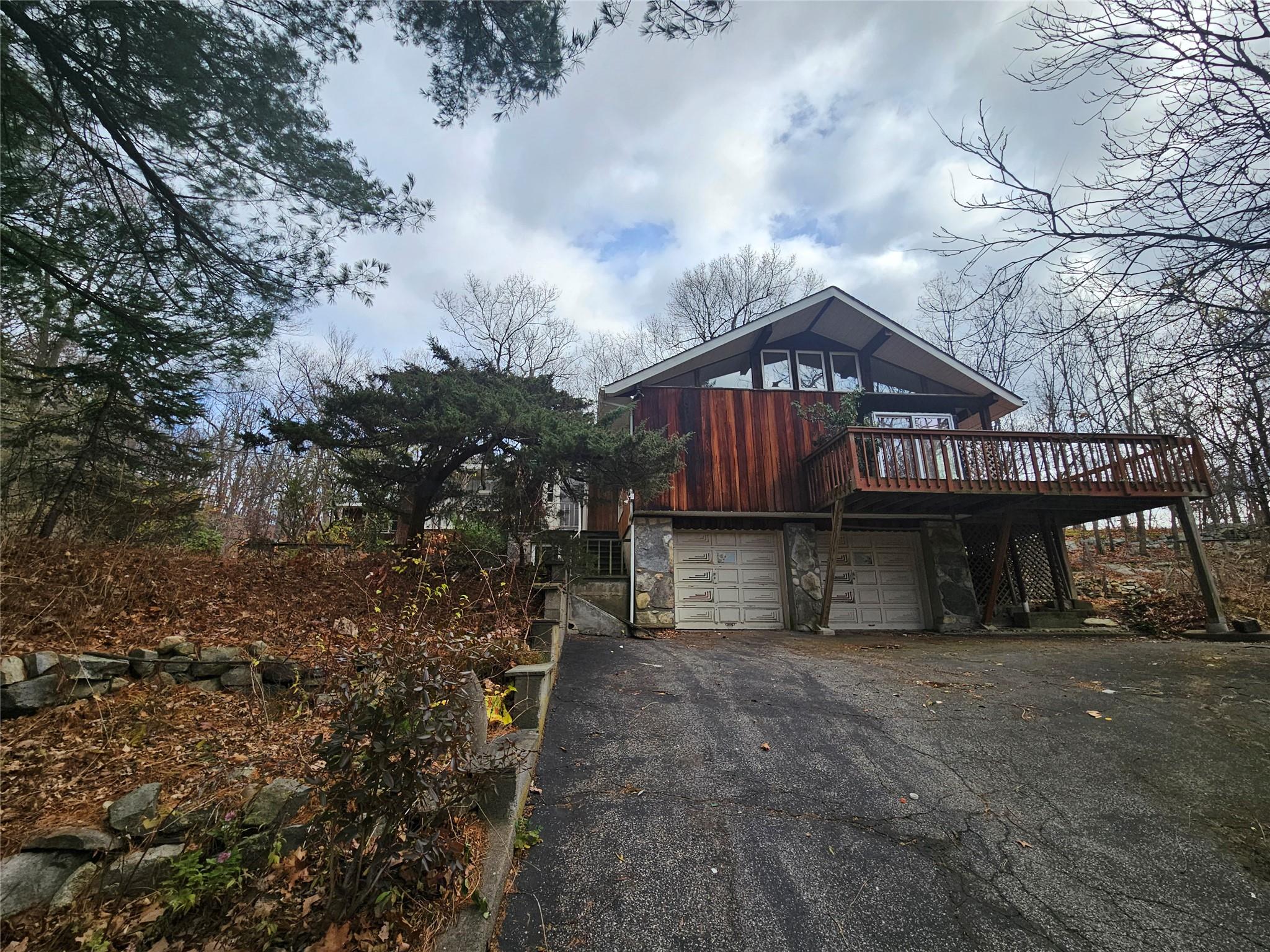 View of front of property with a garage and a deck