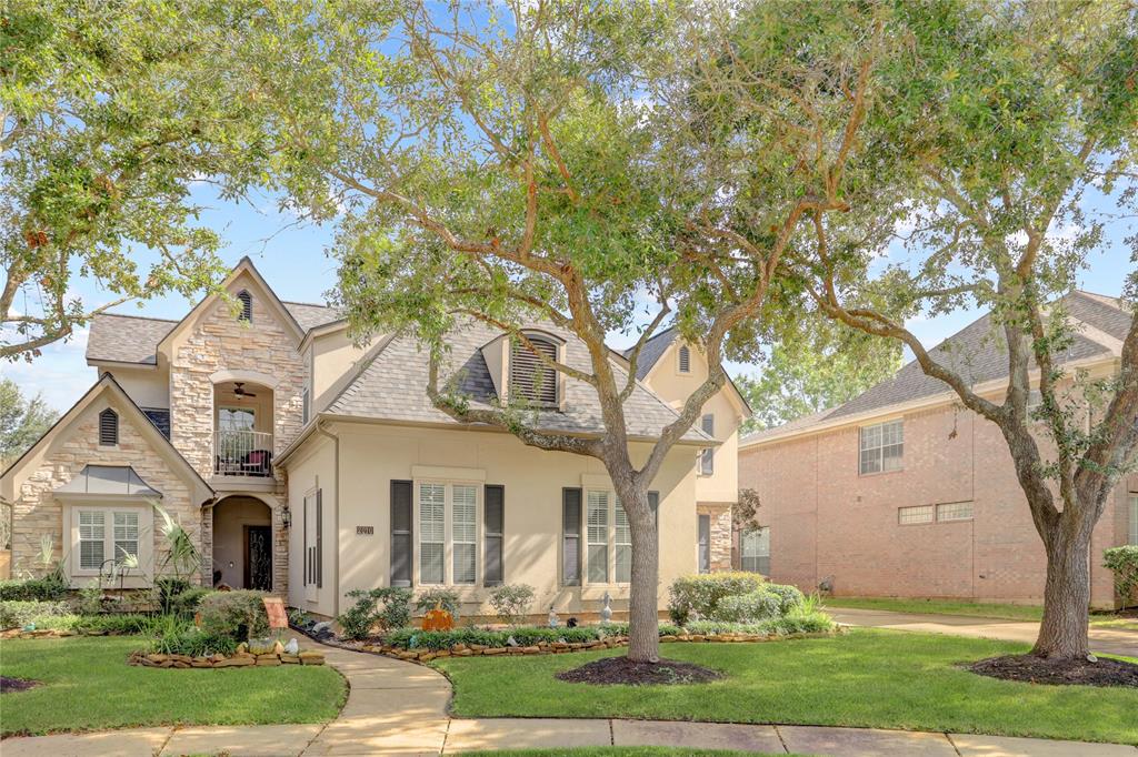 THIS CHARMING HOME EXUDES CHARACTER WITH ITS TEXTURED STONE ACCENTS, ELEGANT SHUTTERS, AND EXPANSIVE UPPER BALCONY.