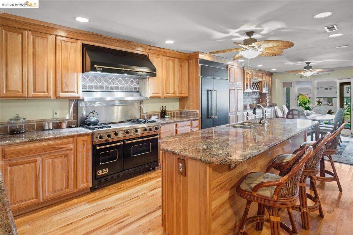 a kitchen with kitchen island granite countertop wooden cabinets and stainless steel appliances