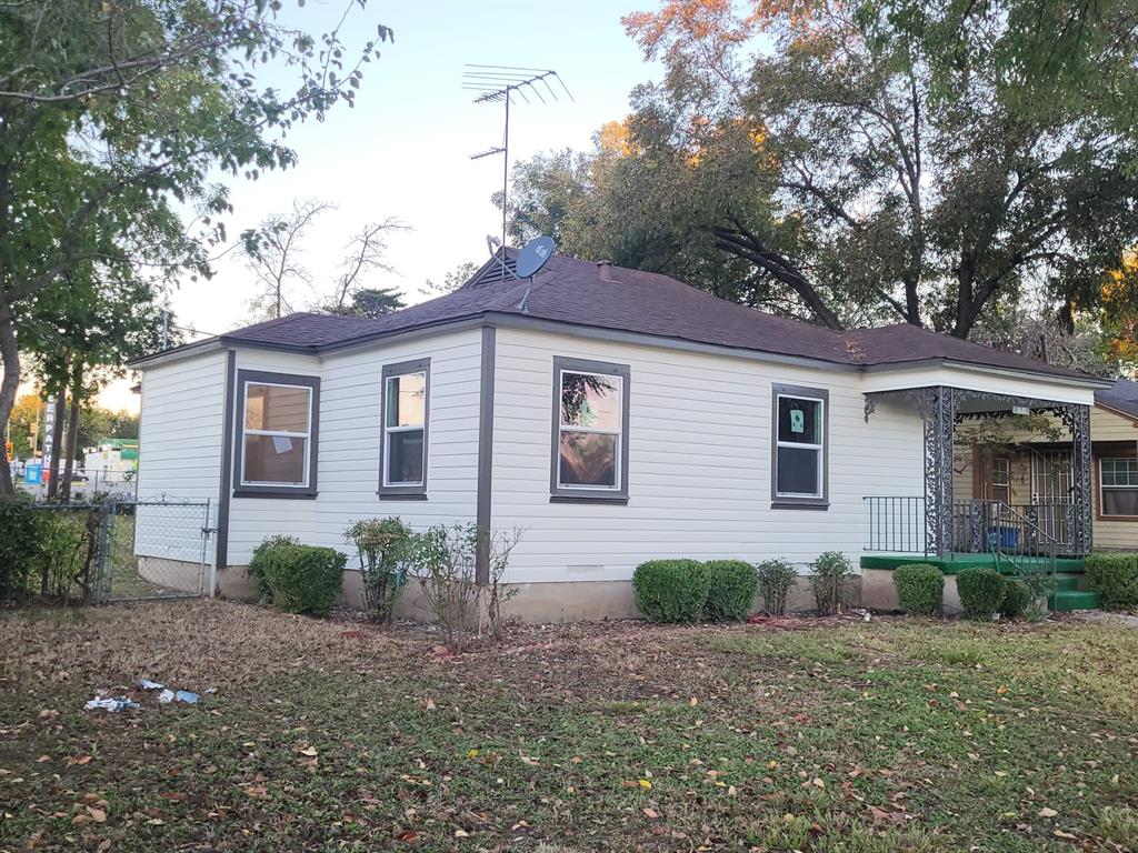 a view of a house with a yard and large tree