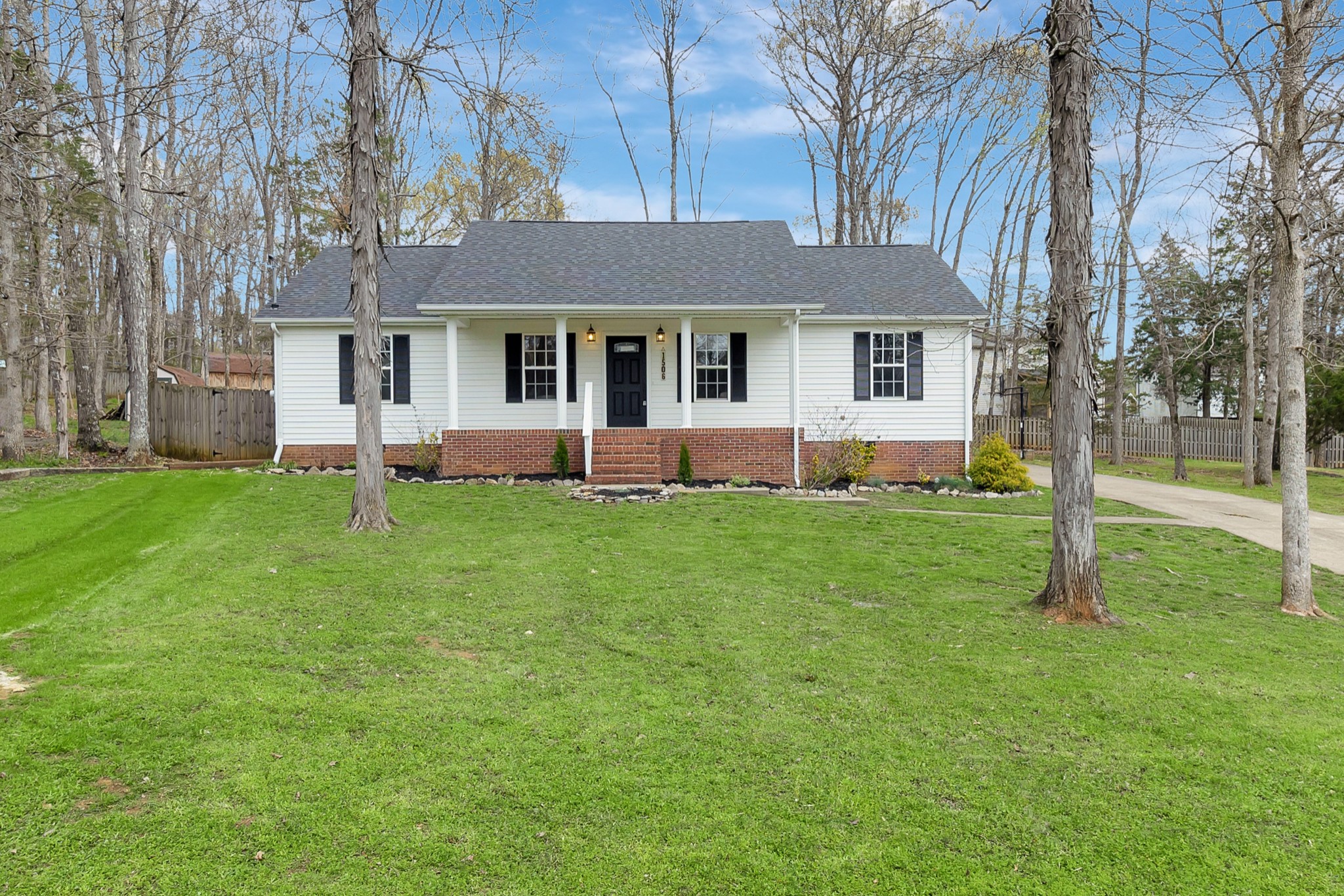 a front view of a house with a yard and trees