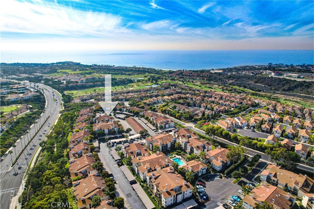 an aerial view of a city with lots of residential buildings ocean and mountain view in back