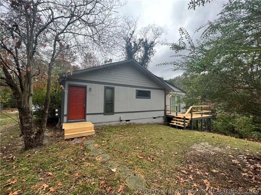 a view of a house with a yard garage and trees