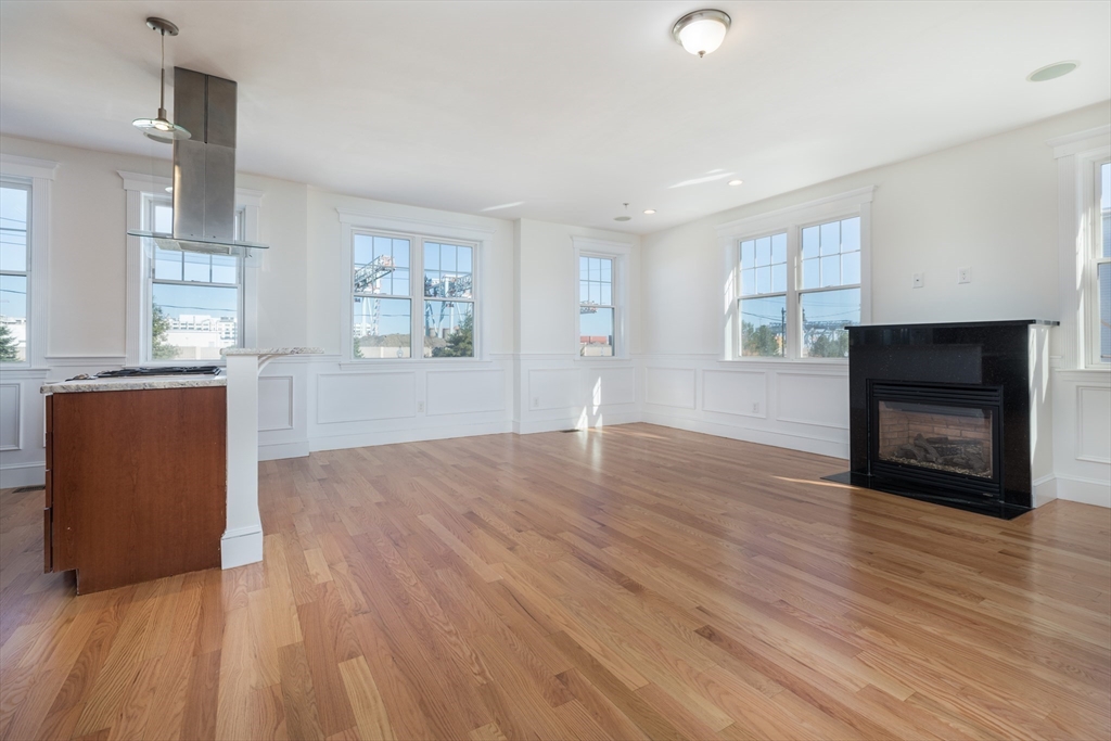 an empty room with wooden floor and fireplace