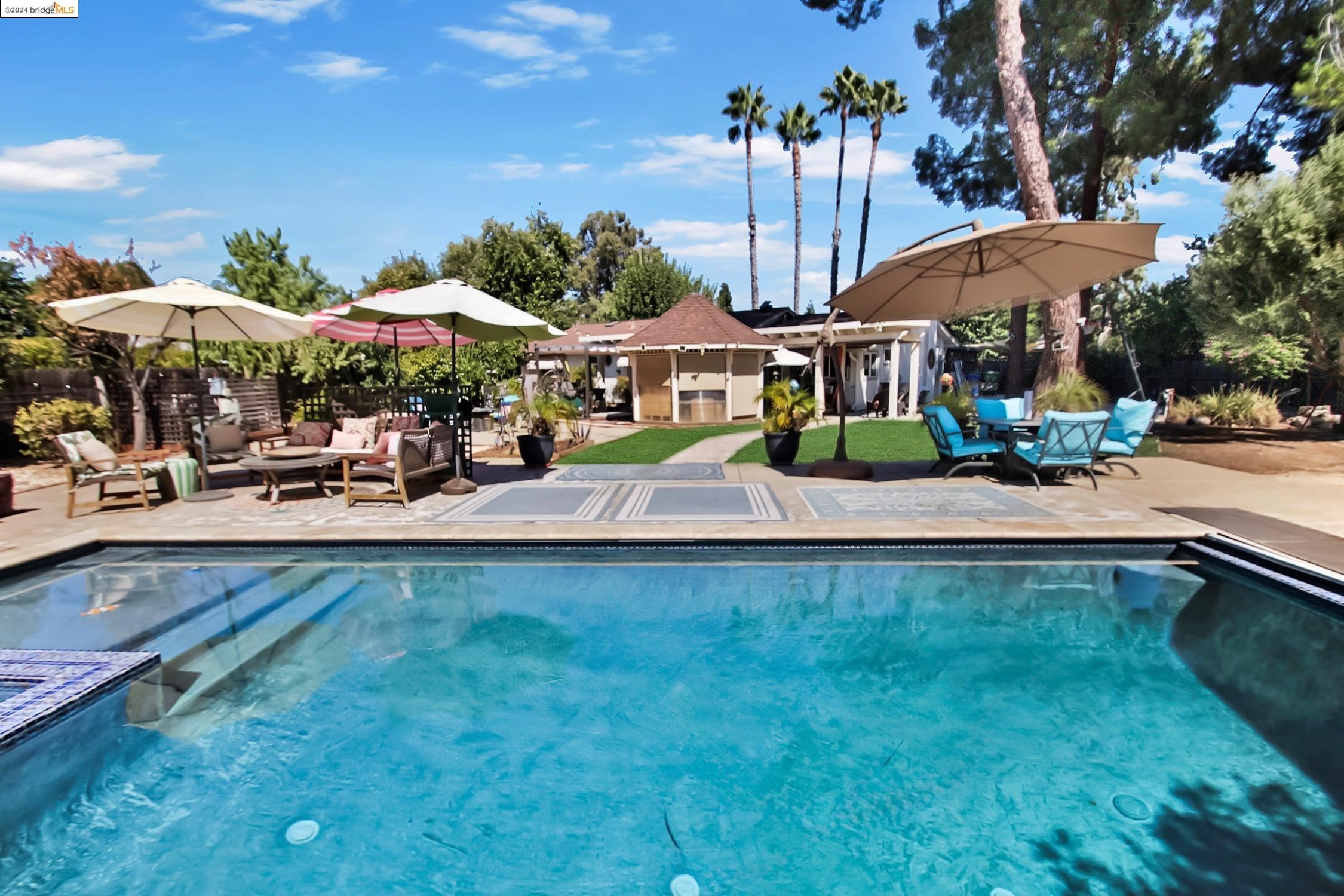 an outdoor space with swimming pool and furniture