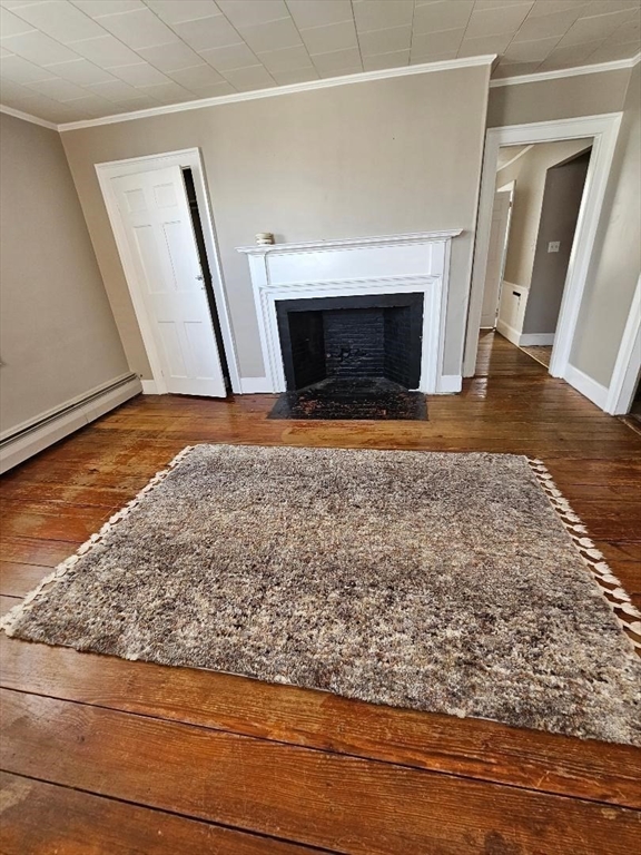 a view of empty room with wooden floor and fireplace