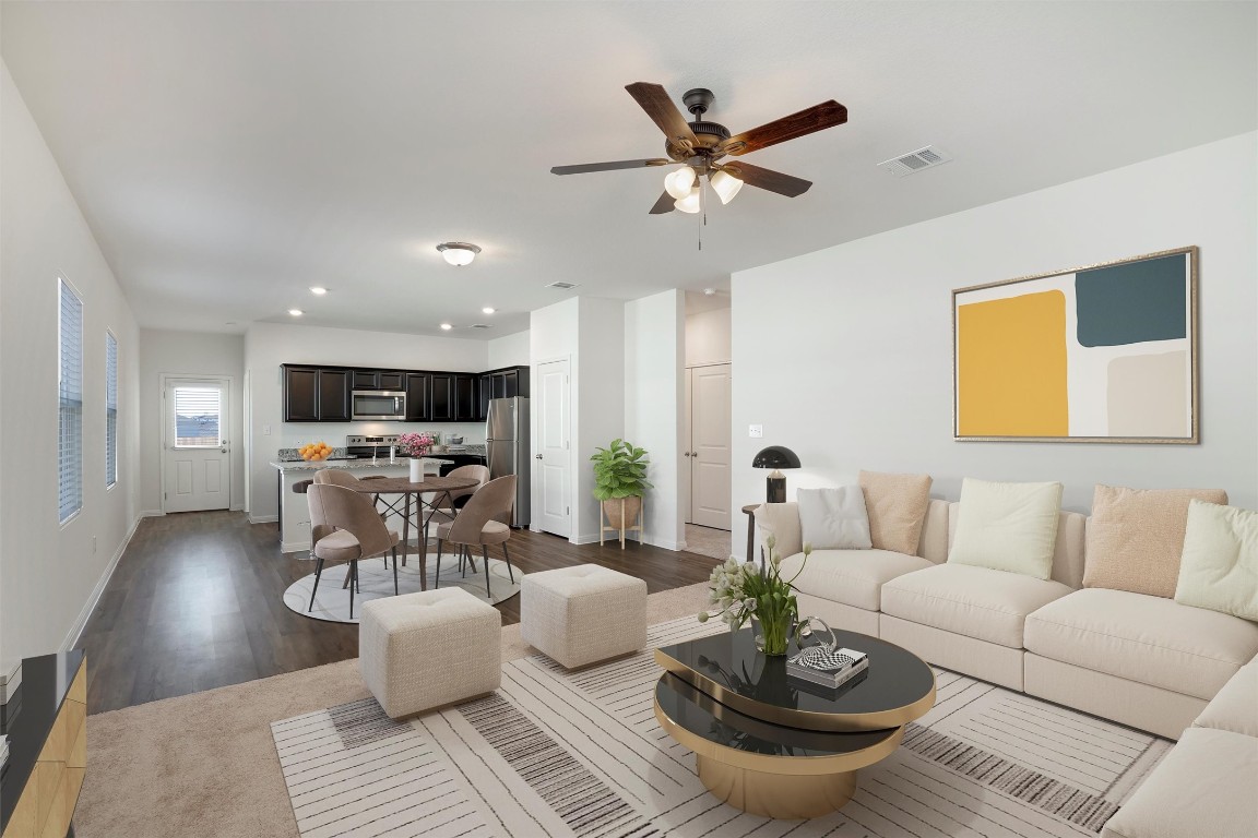 a living room with furniture and a view of kitchen