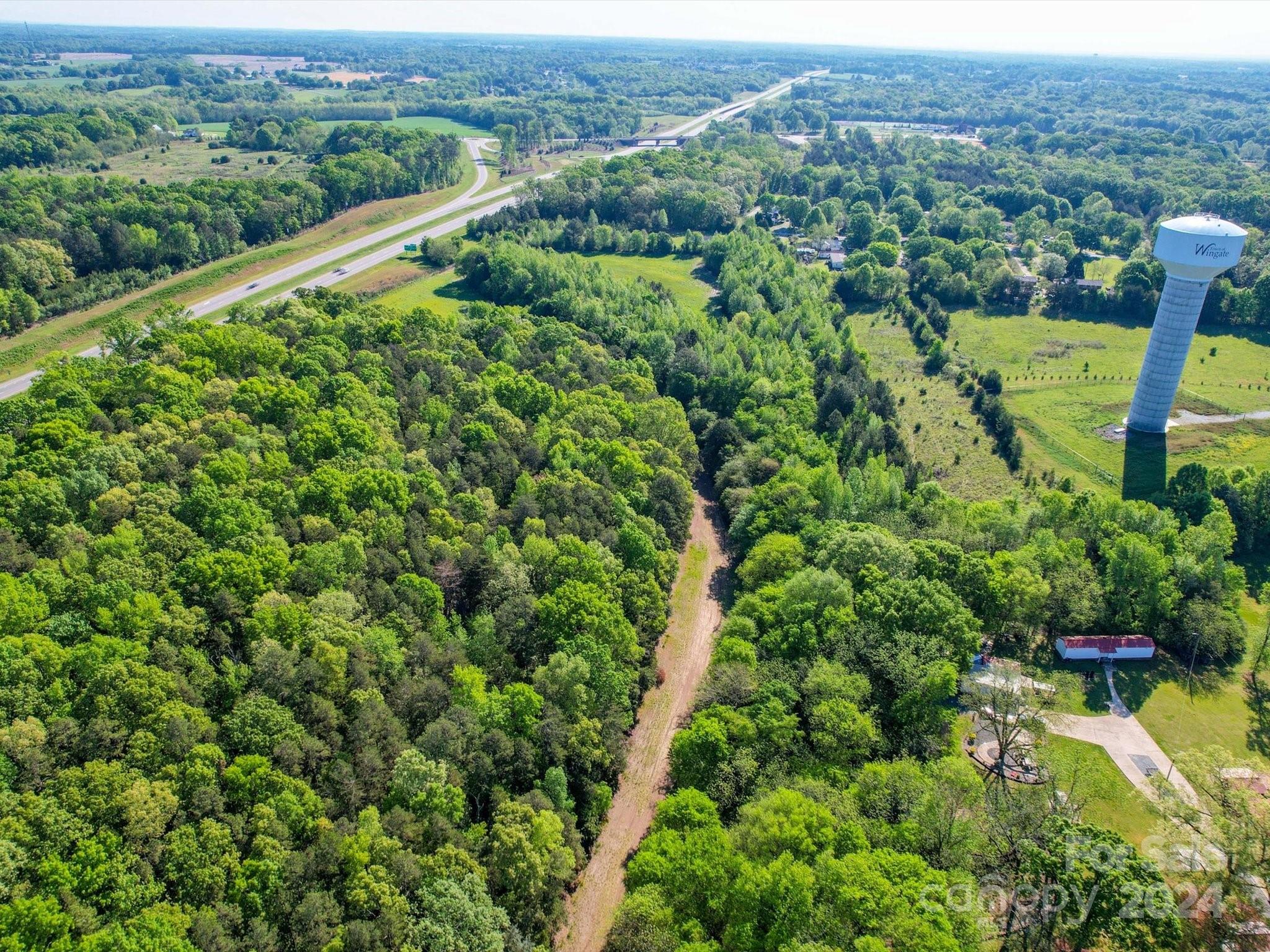 an aerial view of a houses with a lush green forest