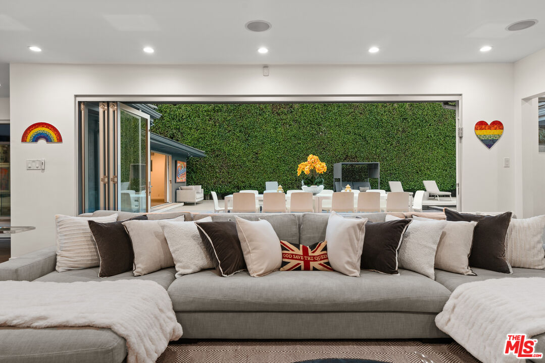 a living room with furniture kitchen view and a large window