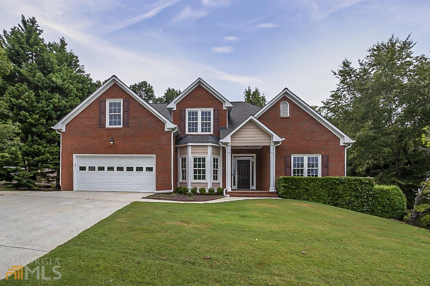 a front view of a house with a yard and garage