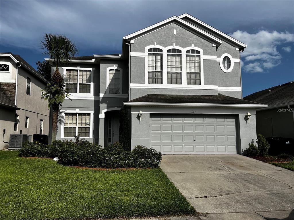 a front view of a house with a yard and garage