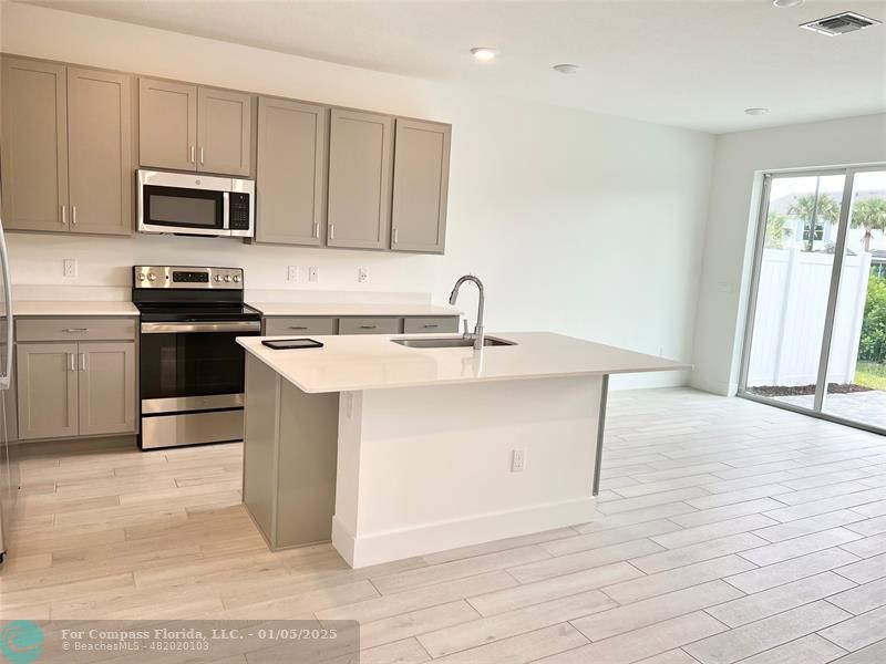 a kitchen with a sink appliances and cabinets