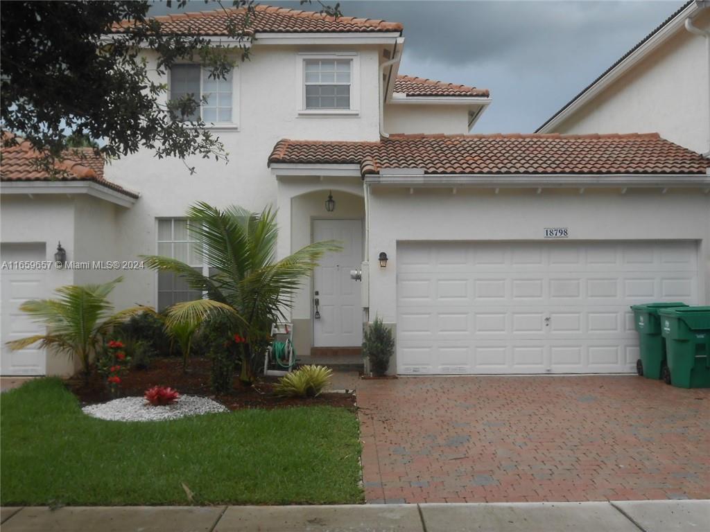 a front view of a house with a yard and garage