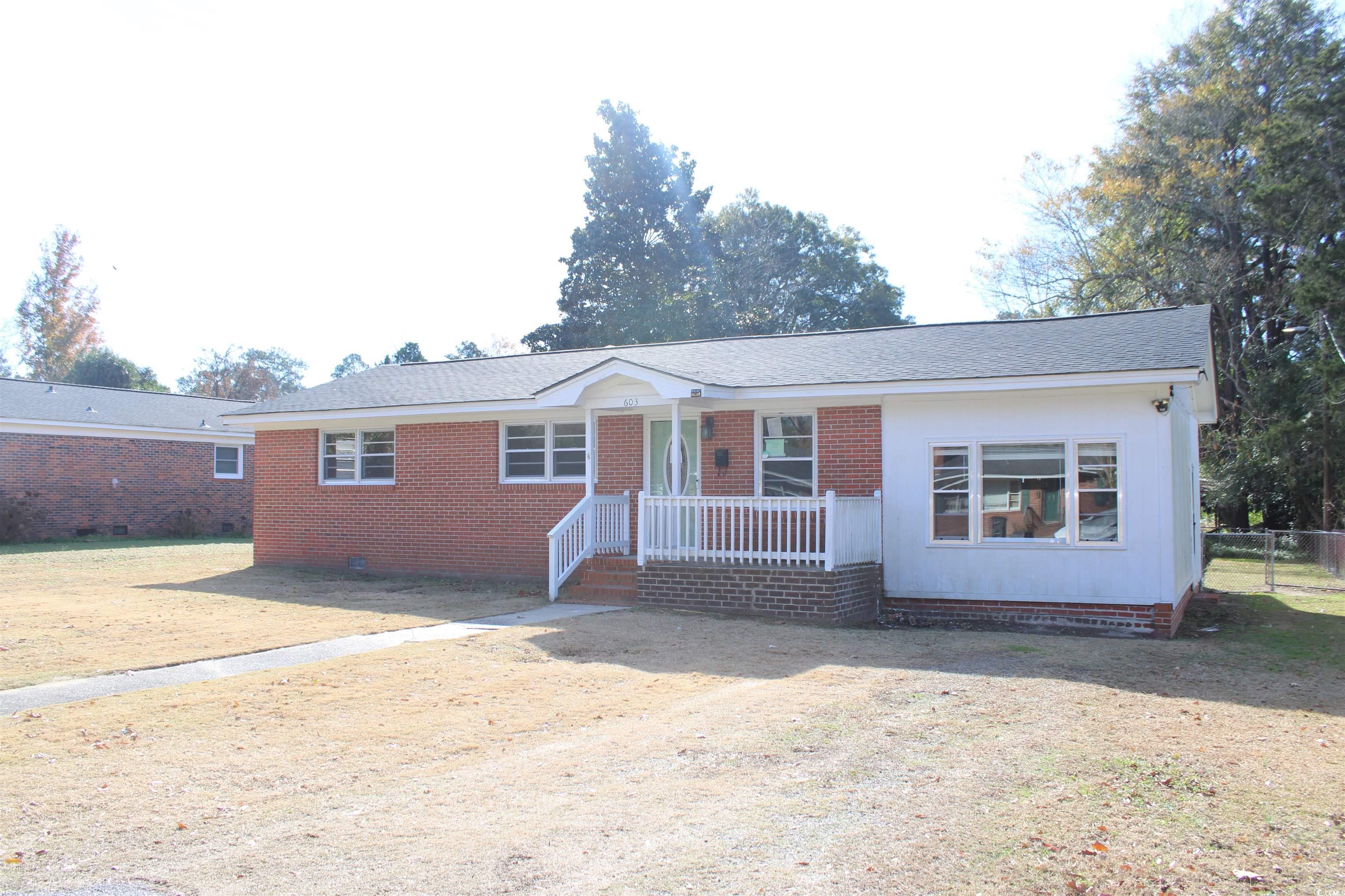 Ranch-style home featuring a front lawn