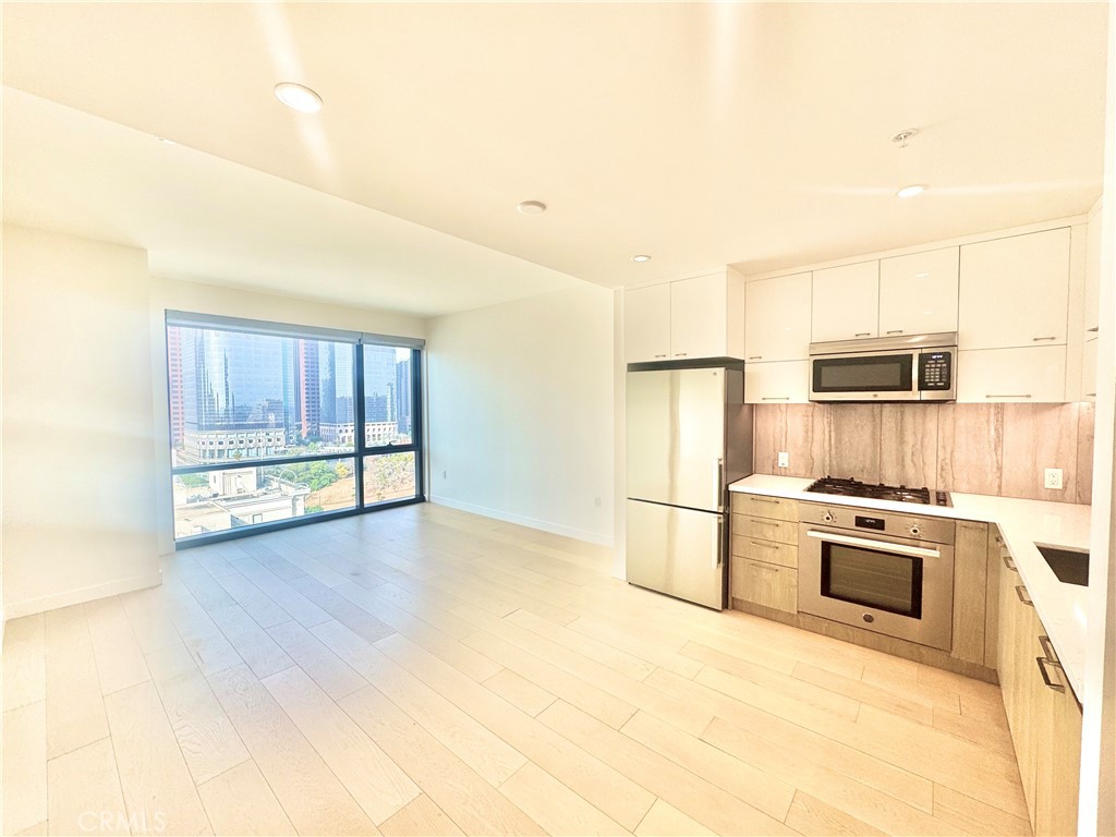 a kitchen with granite countertop a stove a refrigerator and a cabinets