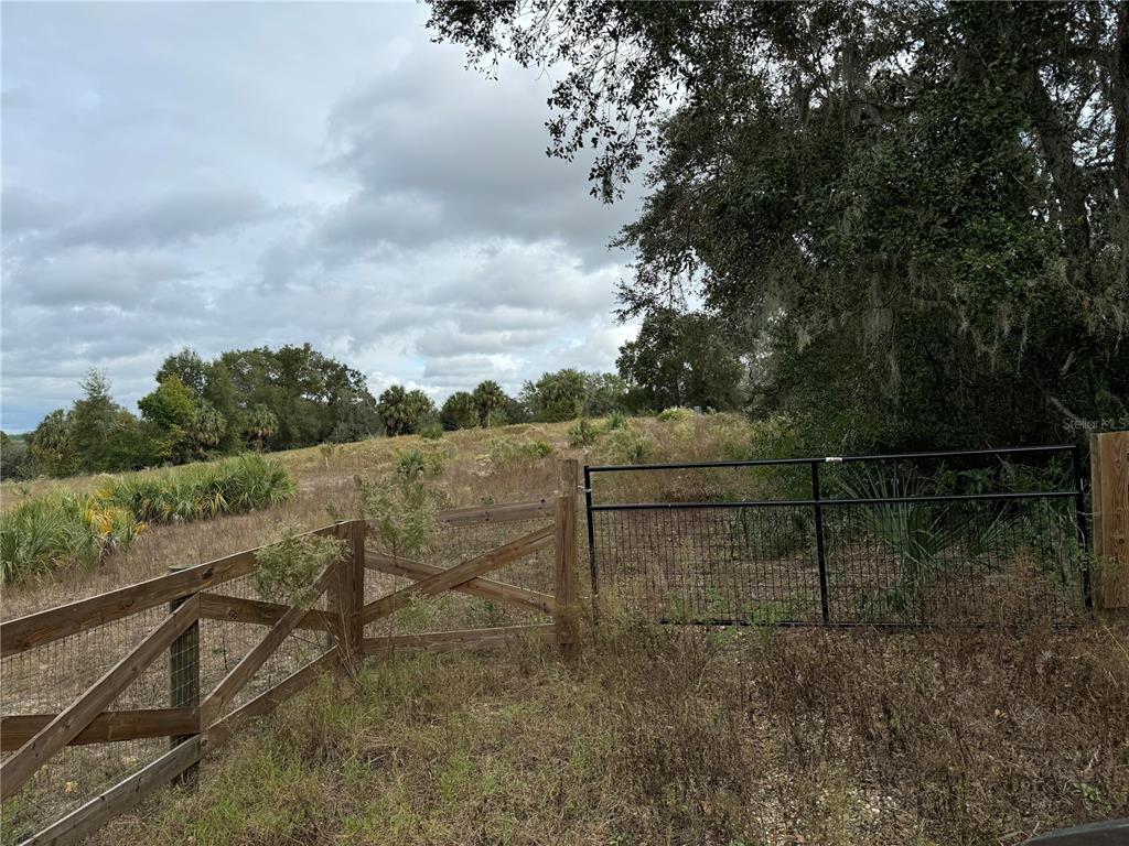 a view of a yard with wooden fence